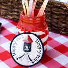 Red and white striped jar with straws on a checkered tablecloth, with Lay's potato chips in the background.