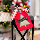 Decorative Christmas tag with 'Peace & Joy' text on a candle in a black lantern.