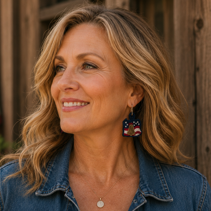 Woman wearing a denim jacket and white top with an American flag in the background