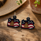 Pair of earrings with American flag design on a wooden surface