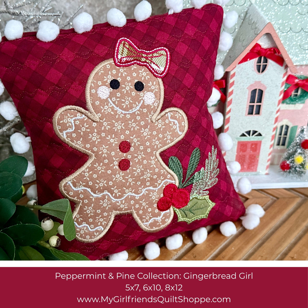 A festive quilted throw pillow featuring an embroidered gingerbread girl with a peppermint bow and holly, set against a dark red plaid background with white pom-pom trim. The pillow is styled on a wooden surface next to a miniature house and green leaves, with a text banner at the bottom identifying the pattern as 'Peppermint Pine Collection: Gingerbread Girl'.
