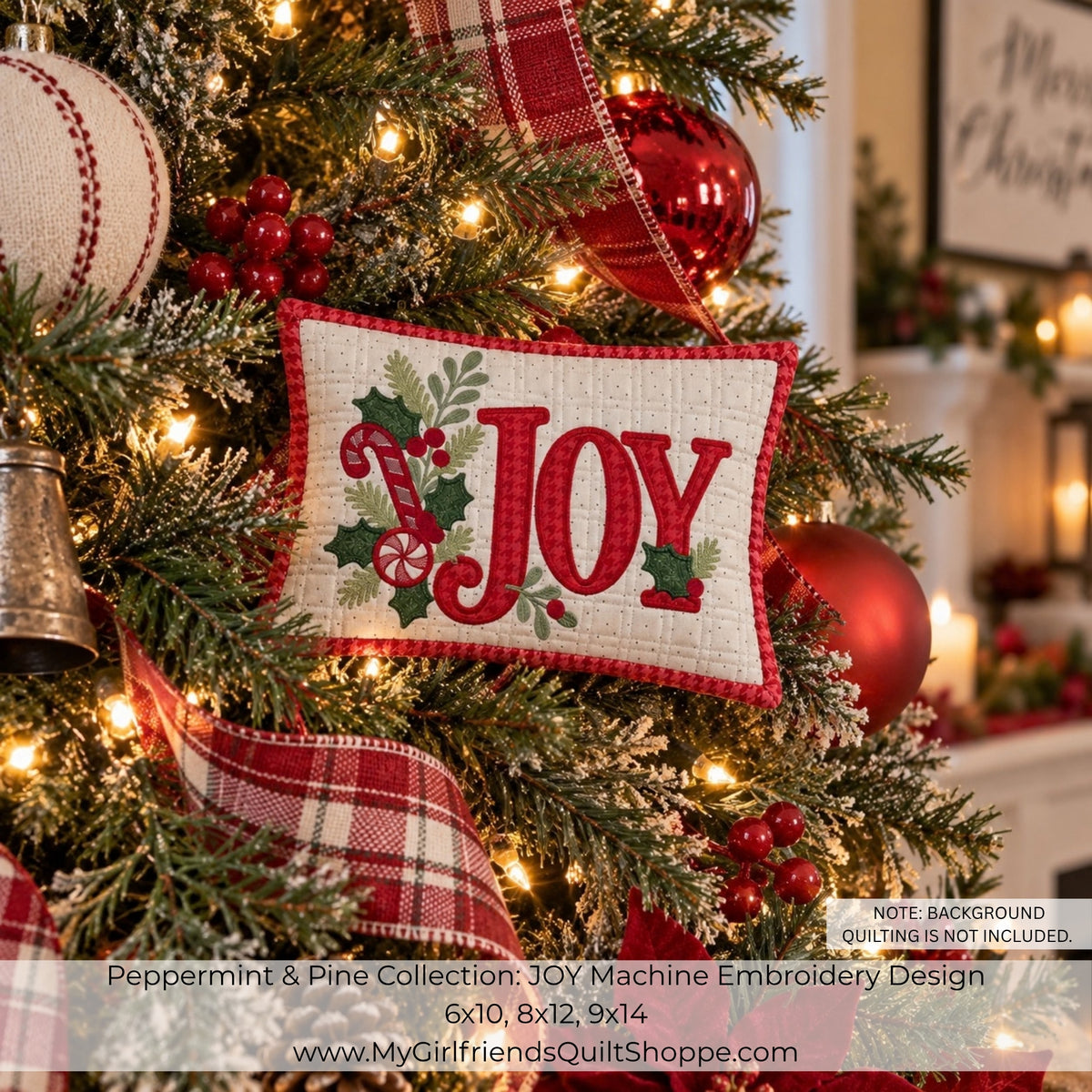 A festive embroidered pillow ornament hanging on a decorated Christmas tree. The square off-white fabric ornament has a red gingham border and the word “JOY” in red script, with green holly leaves and red-and-white plaid ribbon accents.