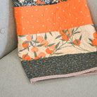 Patchwork quilt with floral and geometric patterns on a chair.
