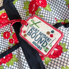 Embroidered tag on a floral fabric with 'Quilt Retreat Bound' text