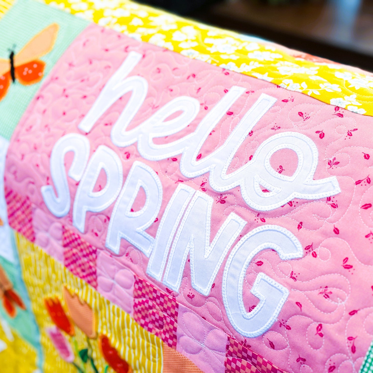 Colorful fabric with 'hello SPRING' text and floral patterns