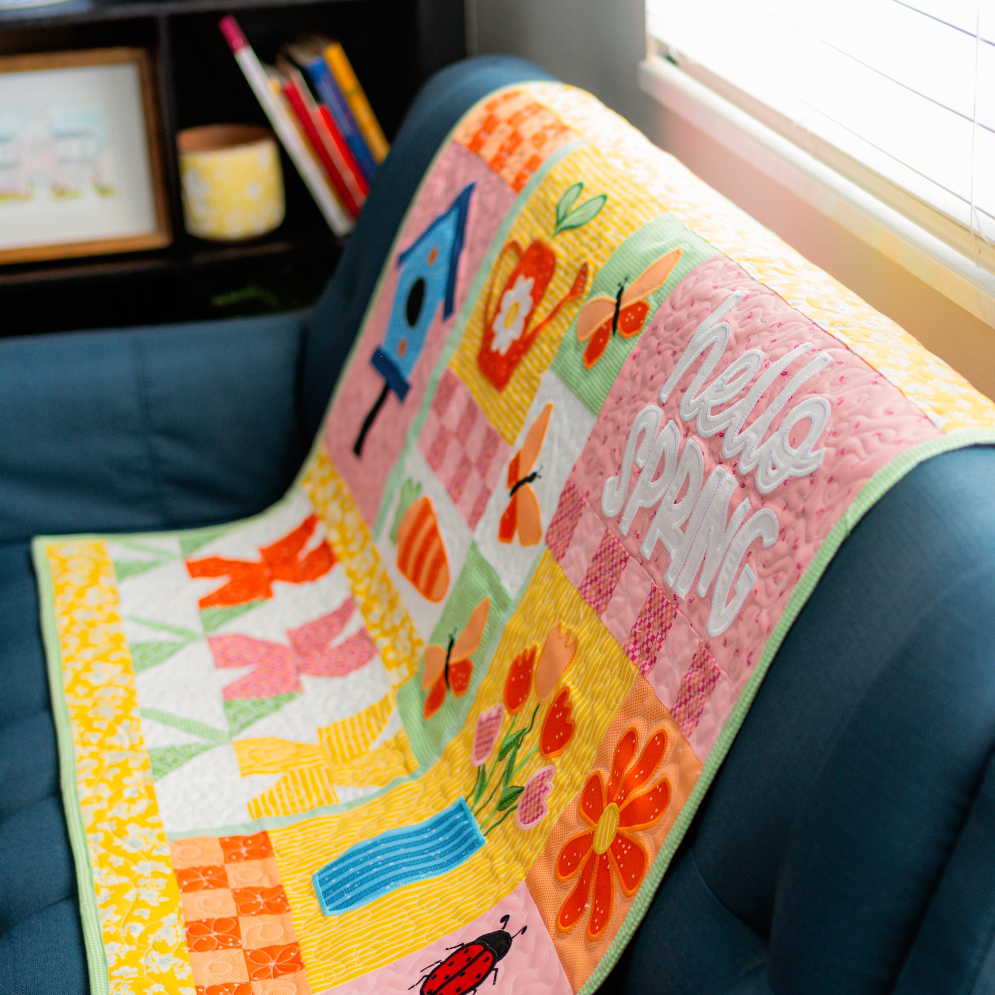 Colorful quilt with floral patterns and text on a blue chair