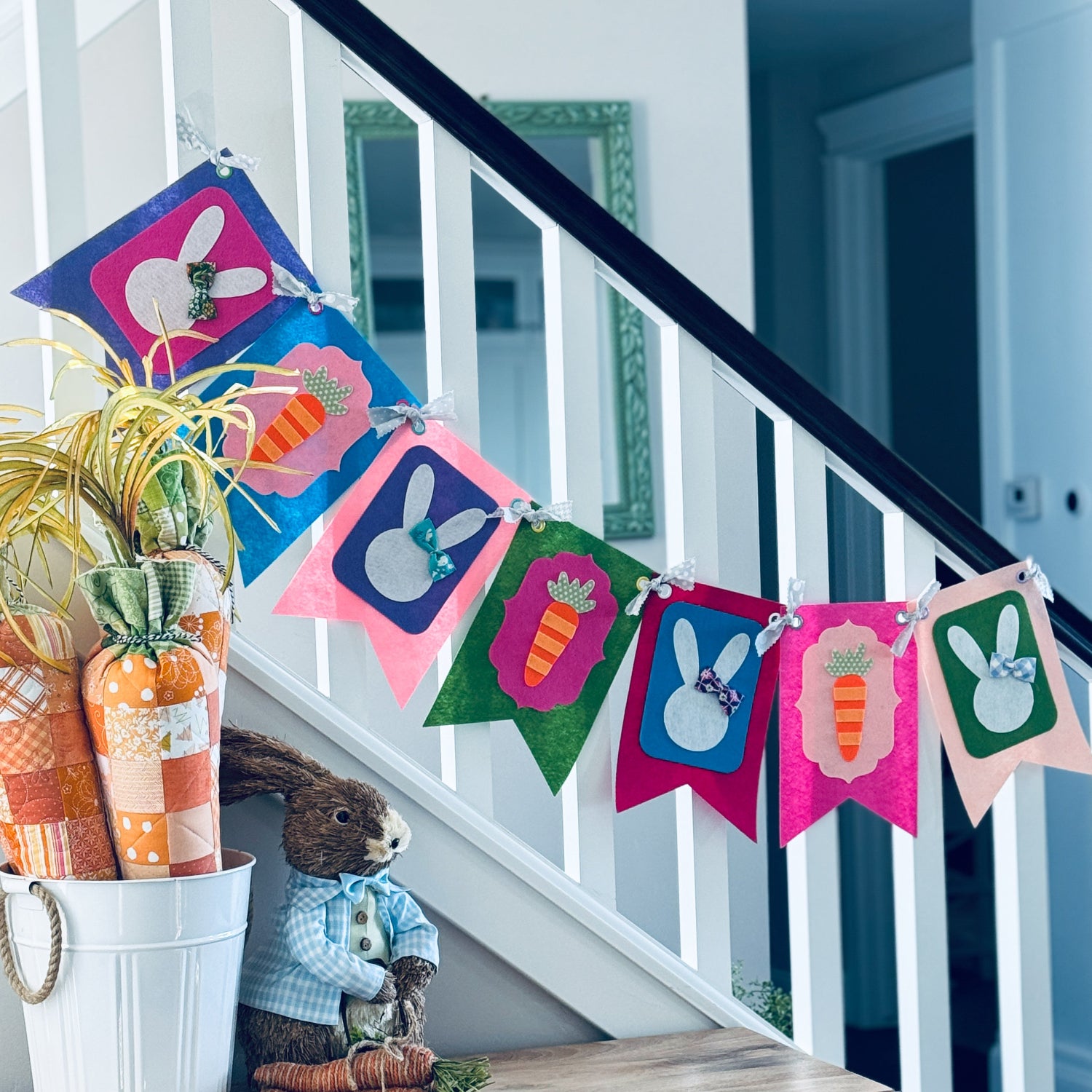 Decorative Easter banner with colorful bunnies and carrots hanging above a staircase.