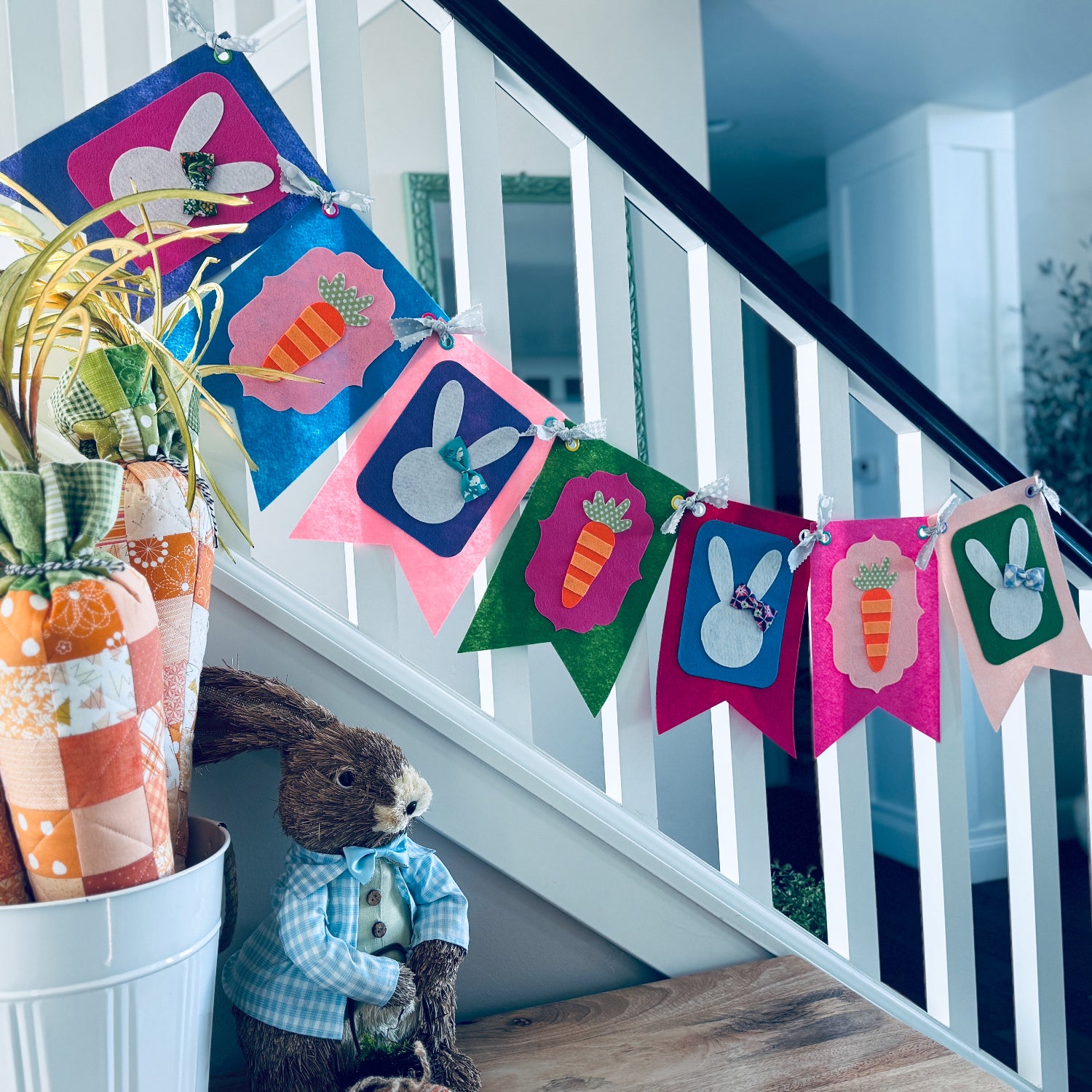 Decorative Easter banner with colorful bunny and carrot designs hanging on a staircase.