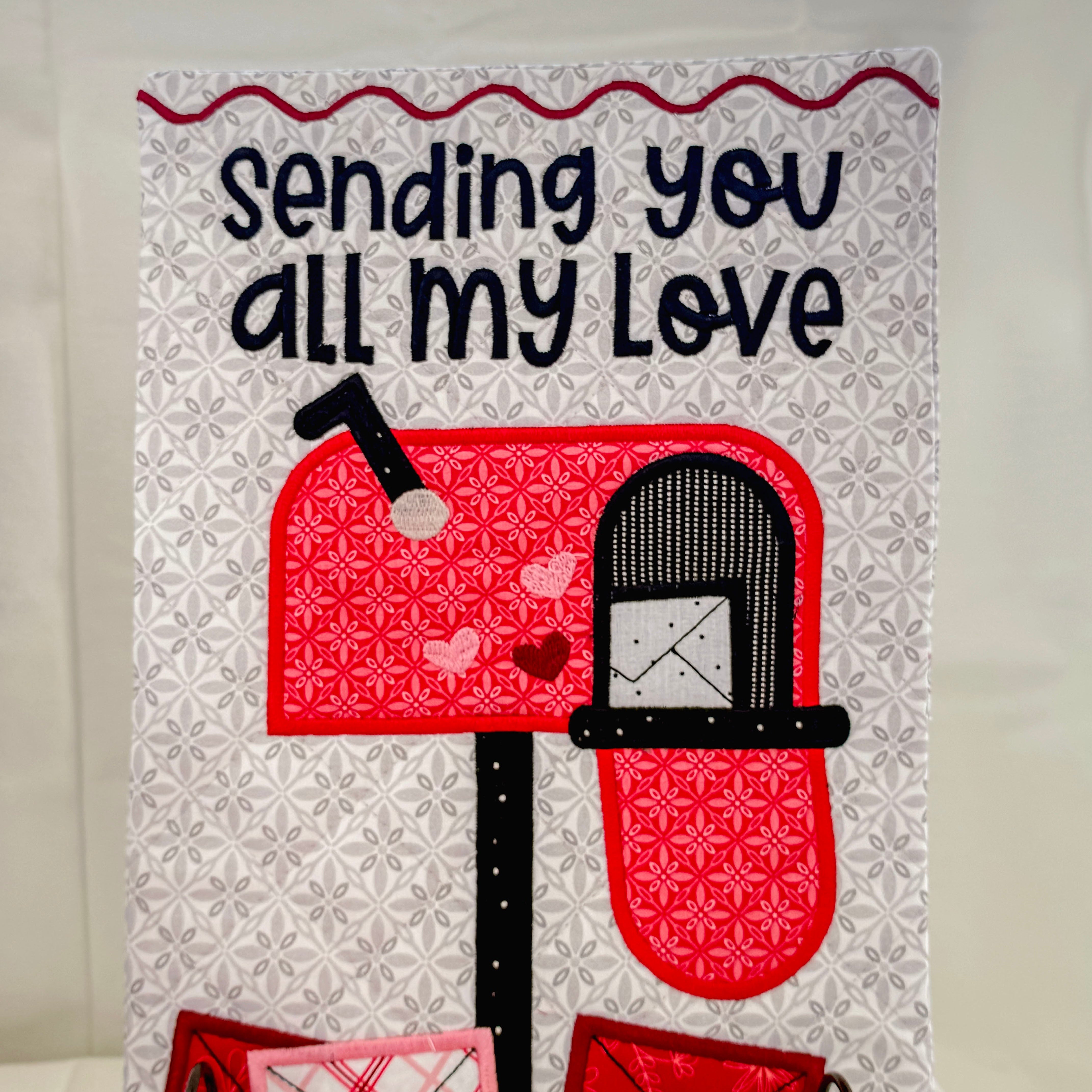 Card with a mailbox and envelopes design, featuring text 'Sending you all my love' on a white background.