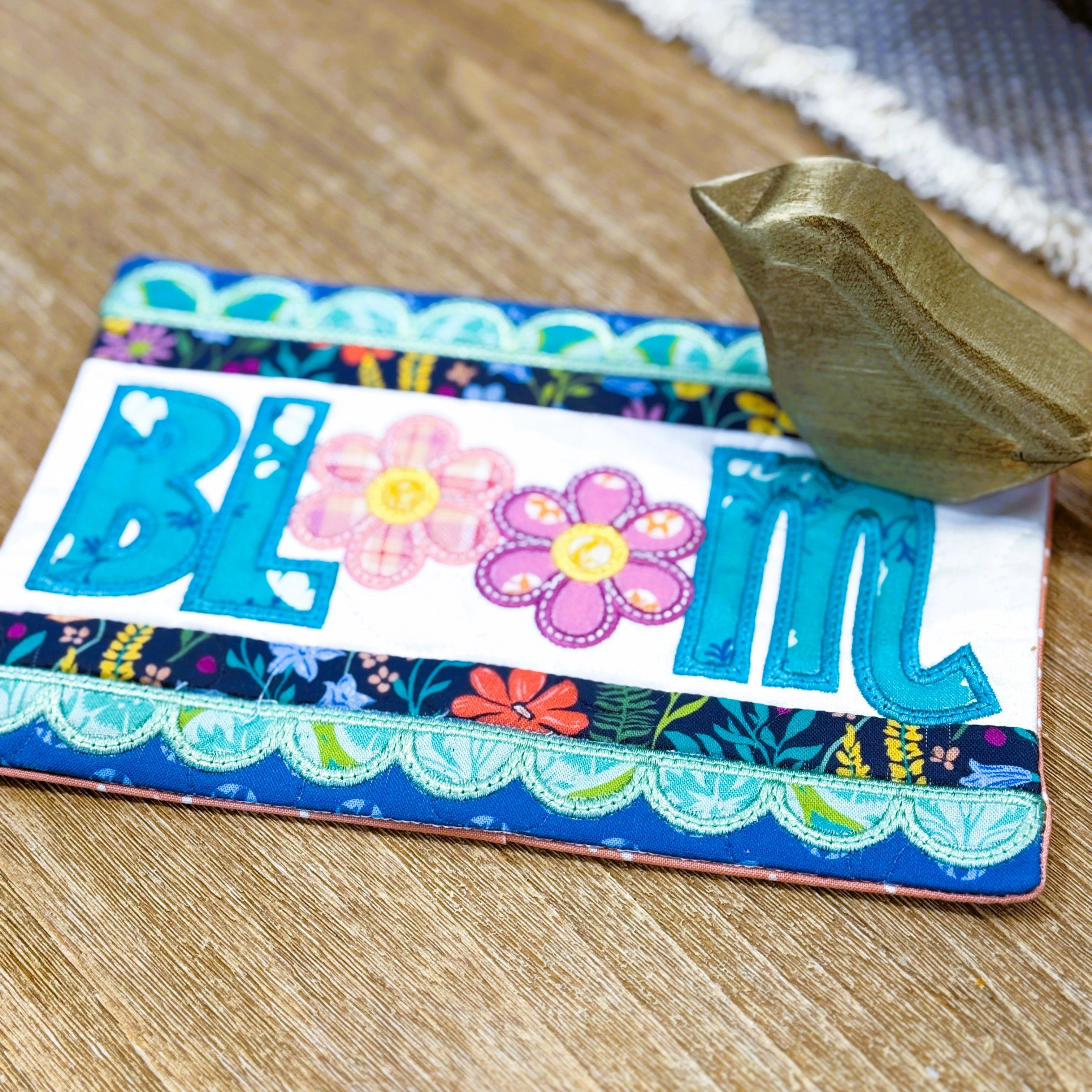 Colorful card with floral design and 'BLIM' text on a wooden surface