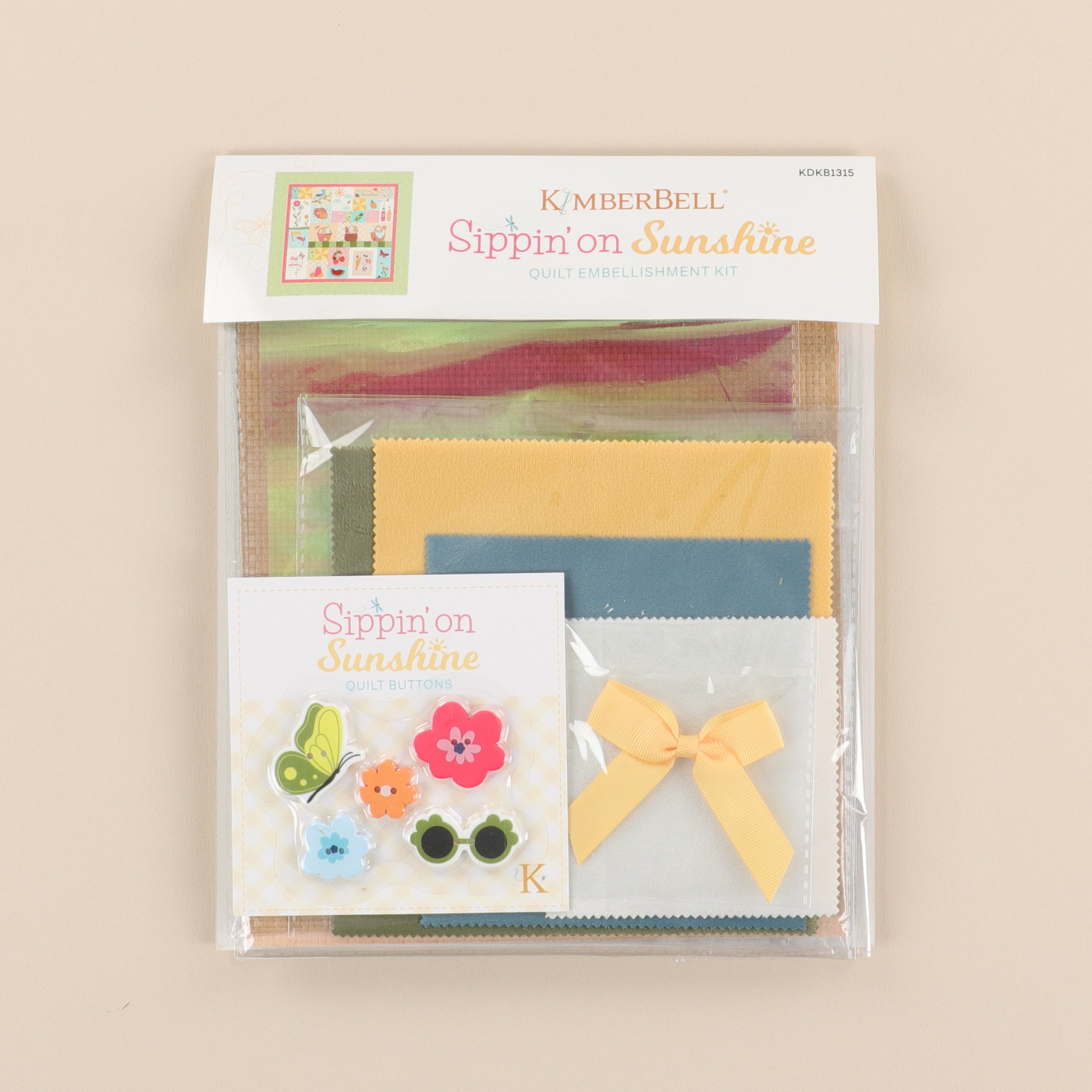 Packaged craft item with colorful fabric squares and decorative elements on a beige background