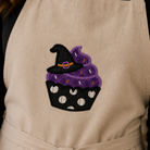 Beige apron with a Halloween-themed cupcake design featuring a witch's hat.