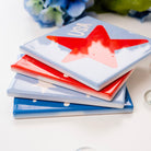 Stack of colorful coasters with a firework design on a white surface with bubbles and flowers.