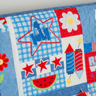 Children's quilt with stars, flowers, and other patterns on a blue background
