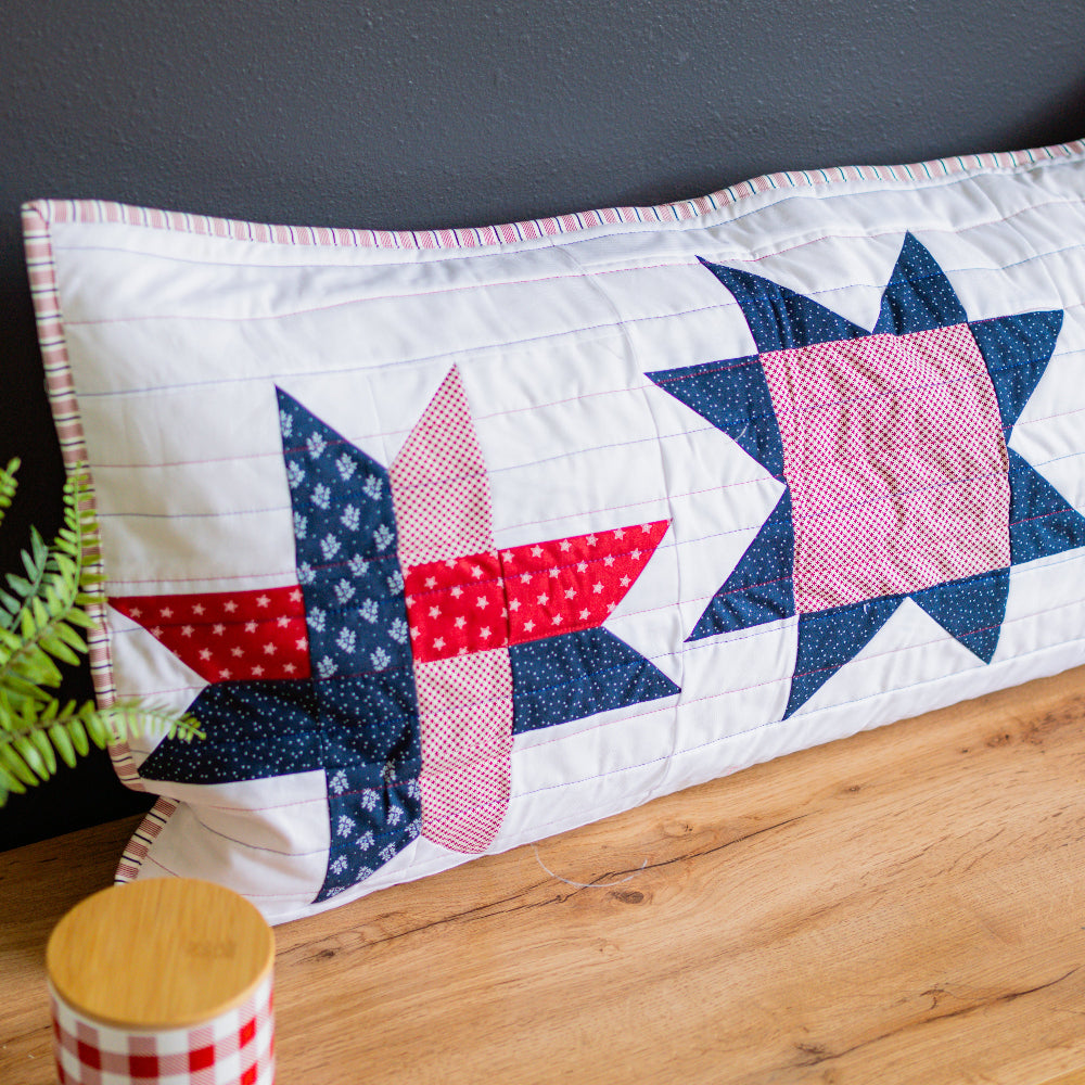 Quilt with star pattern on a wooden surface against a dark gray wall