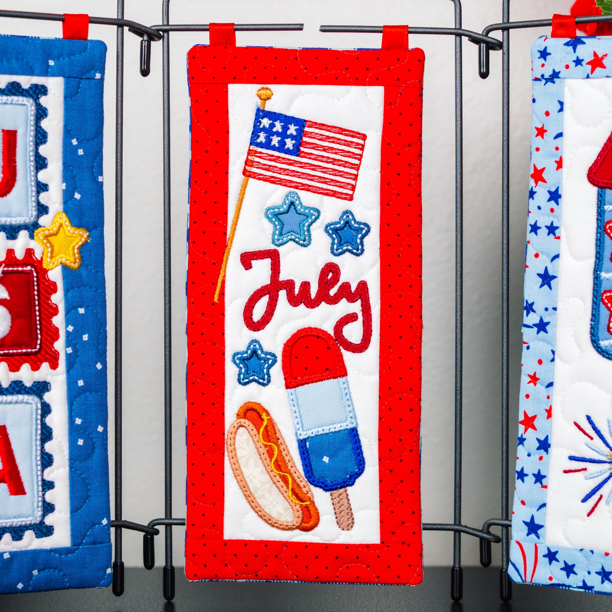Decorative wall hangings with July 4th theme featuring an American flag, ice cream, hot dog, and fireworks.
