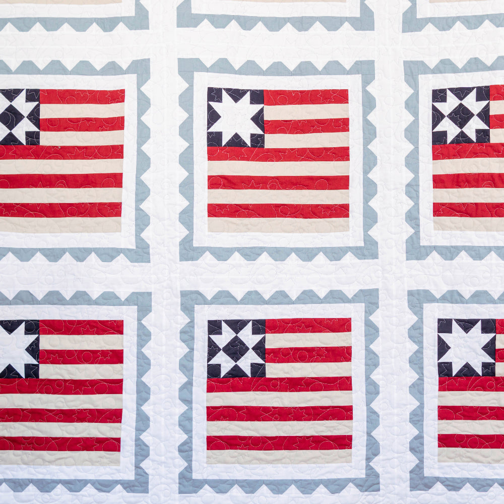 Quilt pattern with American flag designs on a blue background