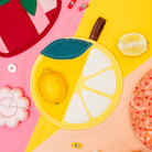 Colorful fruit-shaped plates on a pink and yellow background