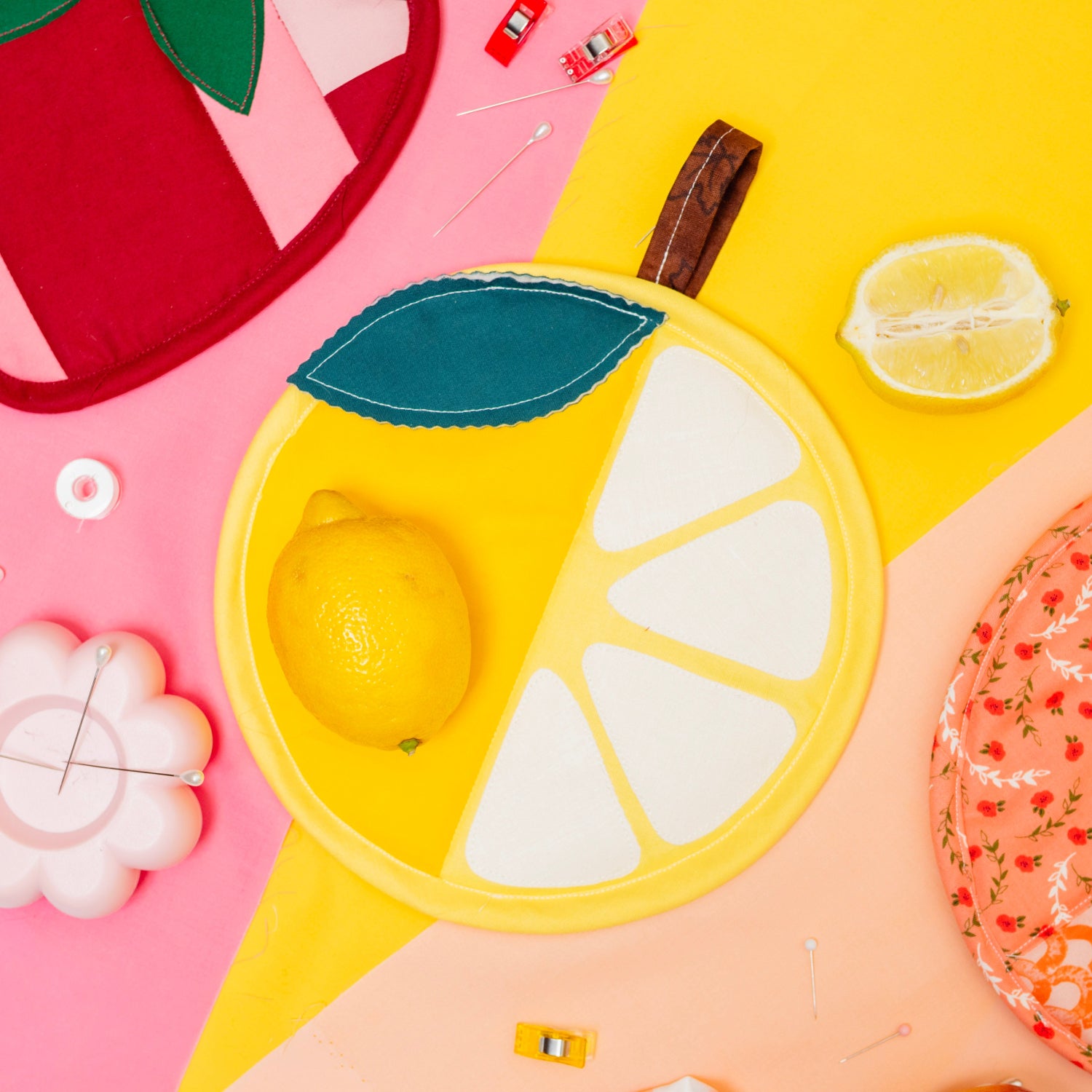 Colorful fruit-shaped plates on a pink and yellow background