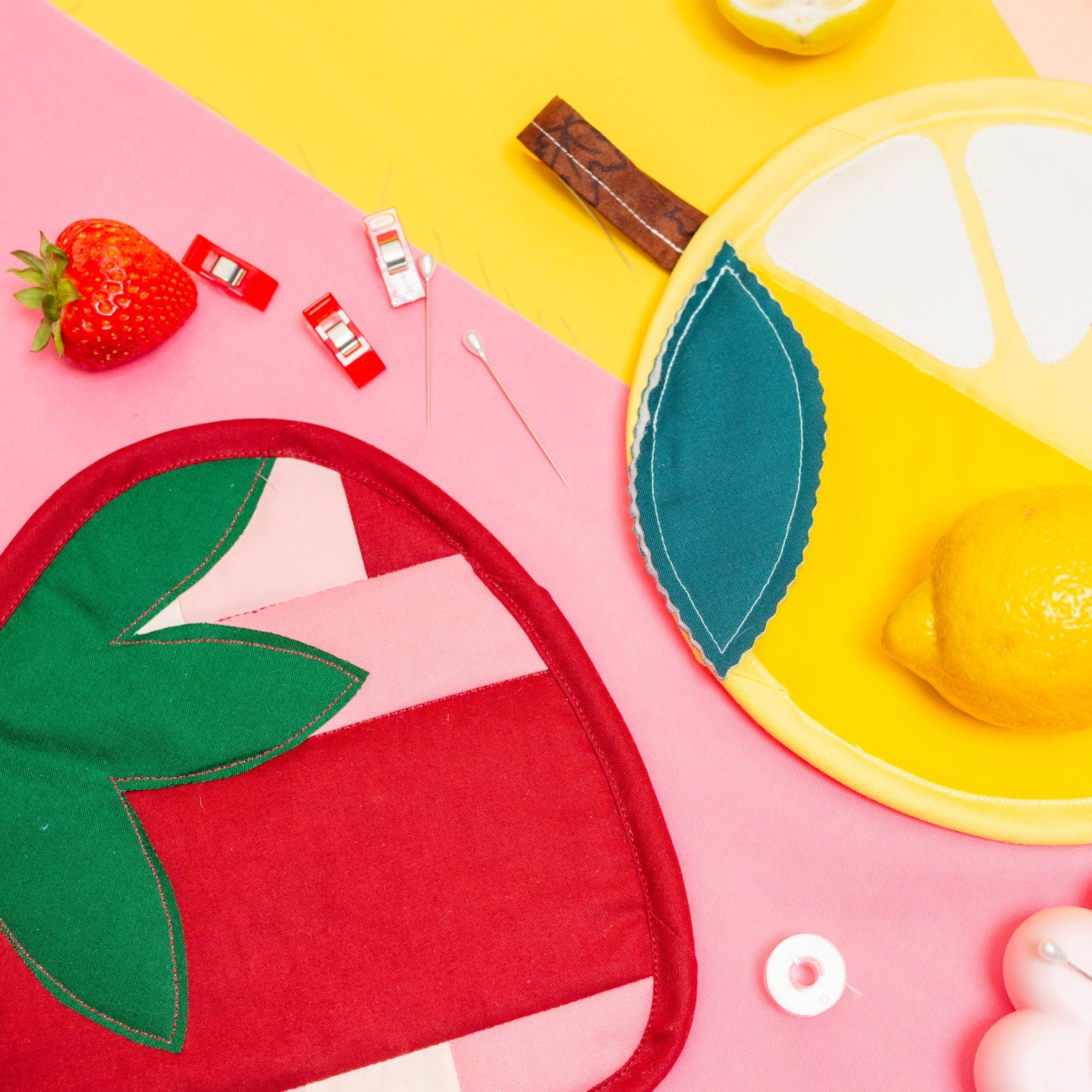 Colorful felt food items including a strawberry, lemon, and ice cream on a pink and yellow background.
