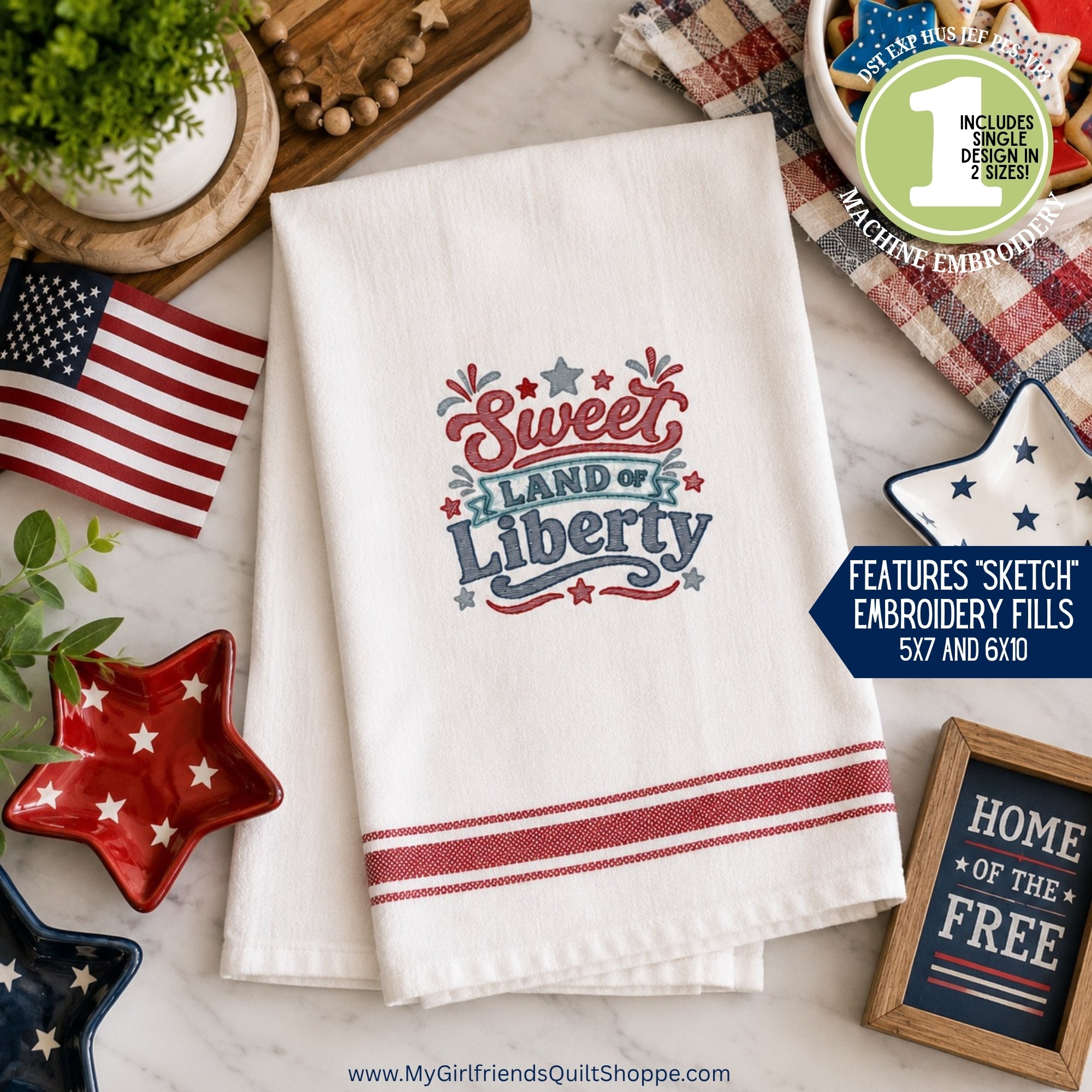 Embroidered towel with 'Sweet Land of Liberty' design on a table with patriotic decor.
