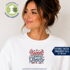 Woman wearing a white sweatshirt with 'Sweet Land of Liberty' design on a plain background