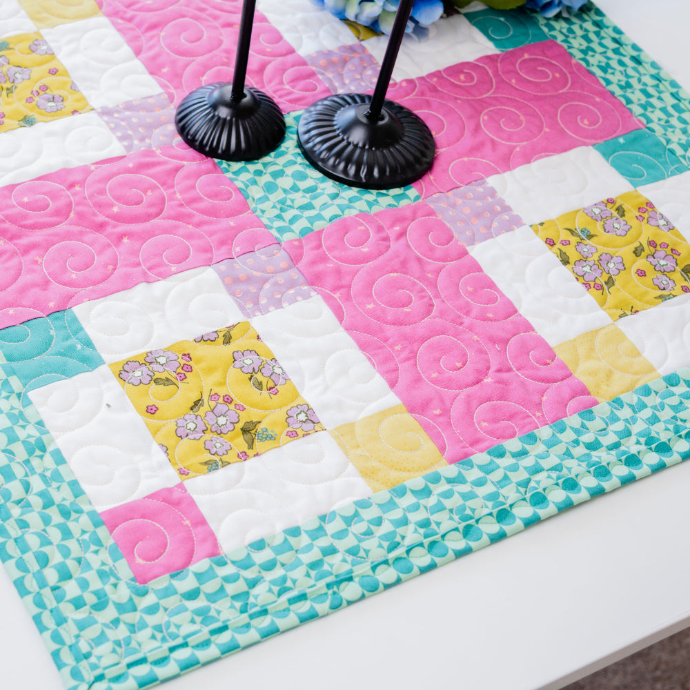 Colorful quilt with a patchwork design on a white surface