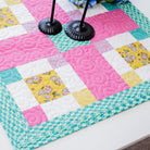Colorful quilt with a patchwork design on a white surface