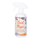 A white plastic spray bottle of Trial Magic Liquid Fabric Stabilizer with a white trigger spray top and a colorful label featuring orange and purple text.