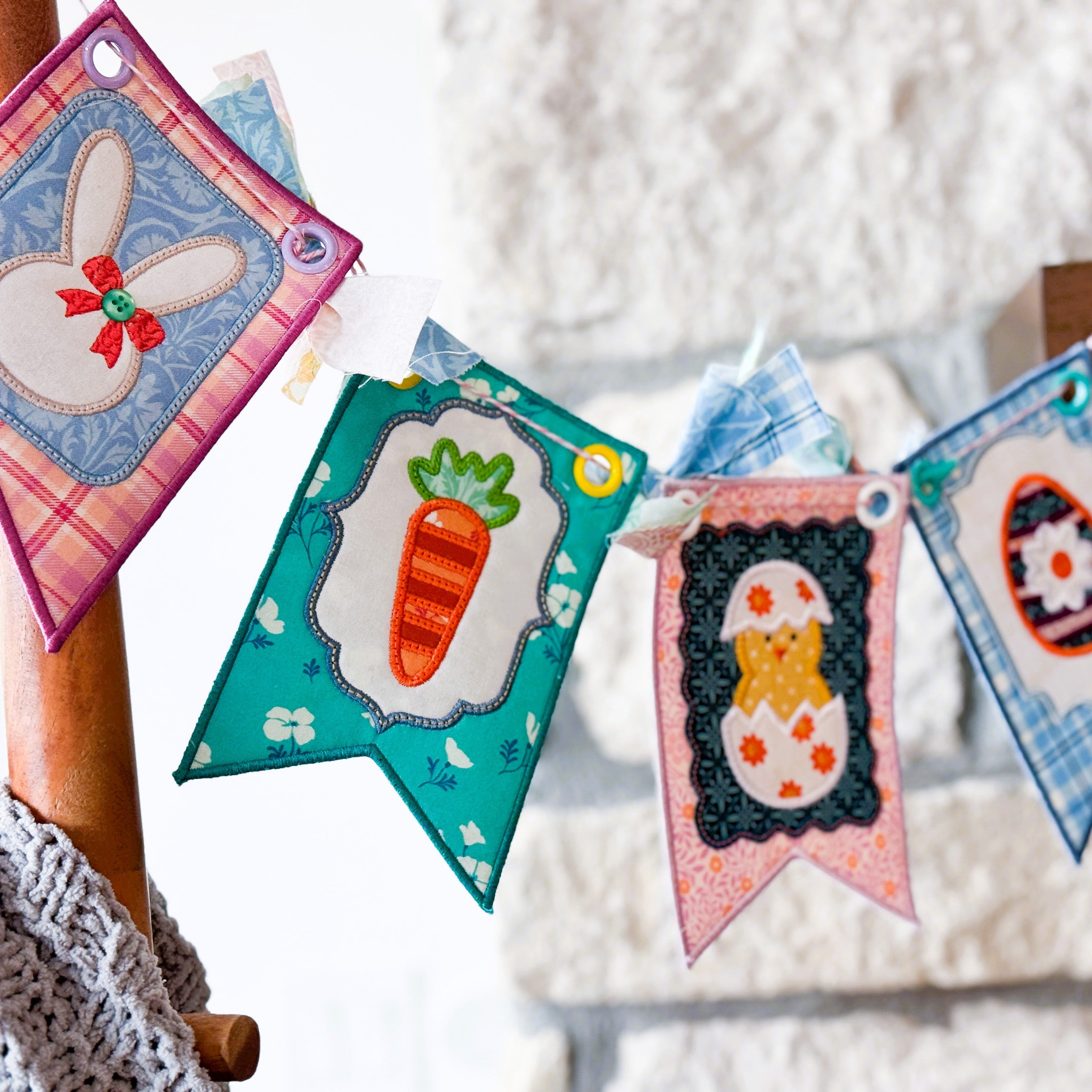 Colorful Easter-themed fabric banners hanging on a wooden chair.