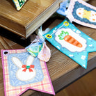 Colorful Easter-themed fabric flags on a wooden surface