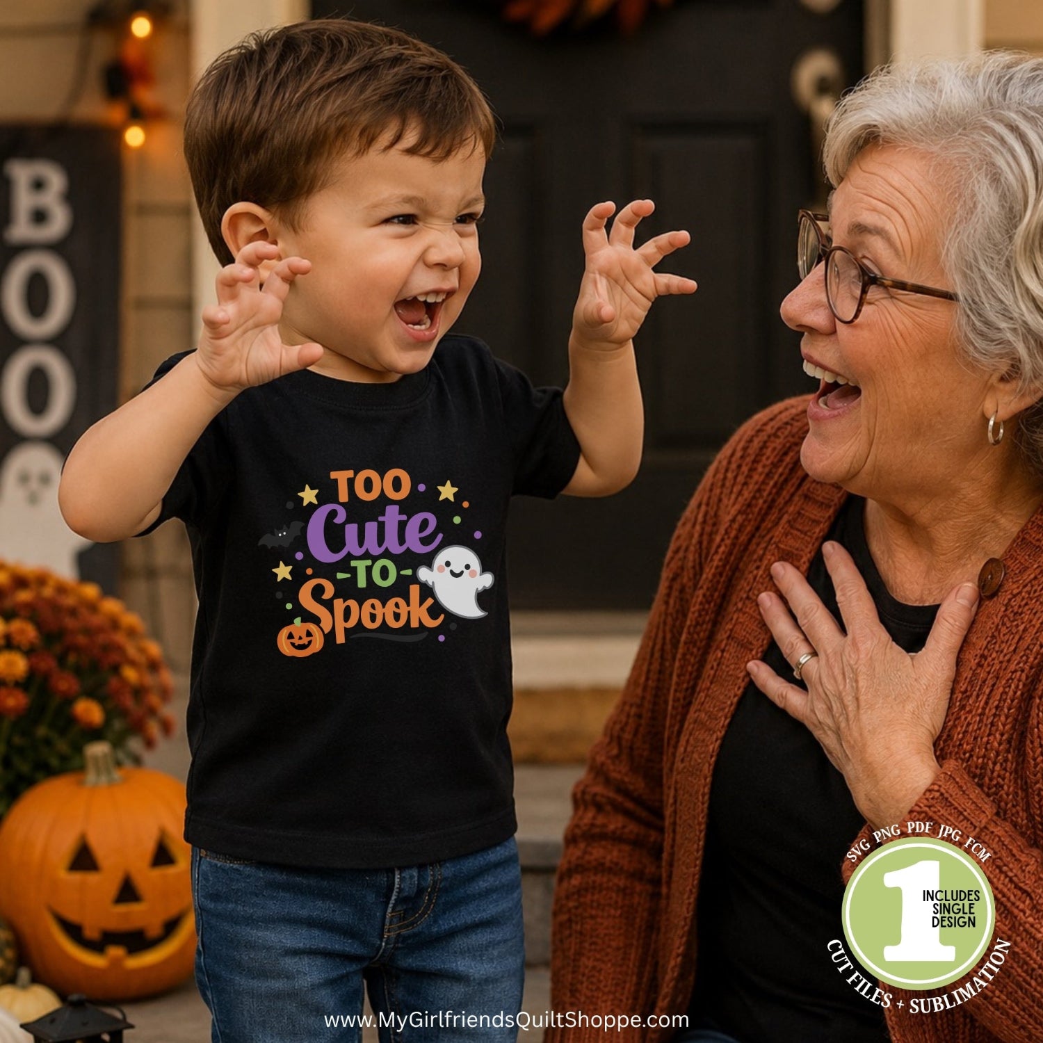 A young boy wearing a black graphic t-shirt that reads 'Too Cute to Spook' in purple, orange, and white, standing next to an older woman in a cozy outdoor setting with pumpkins and fall decorations.