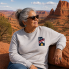Woman wearing a sweatshirt with a logo sitting in a desert landscape