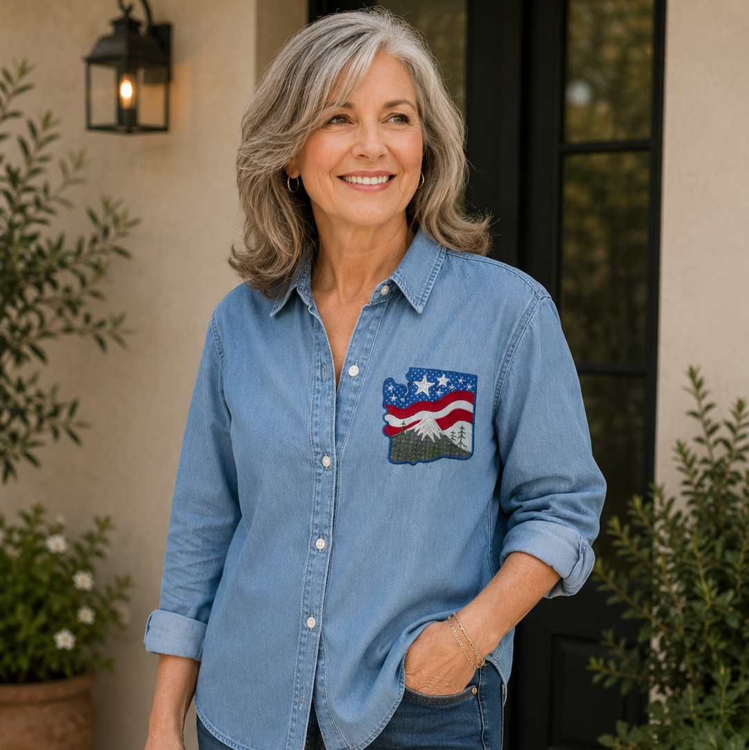 Woman wearing a blue denim shirt with a flag design, standing outdoors.