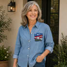 Woman wearing a blue denim shirt with a flag design, standing outdoors.