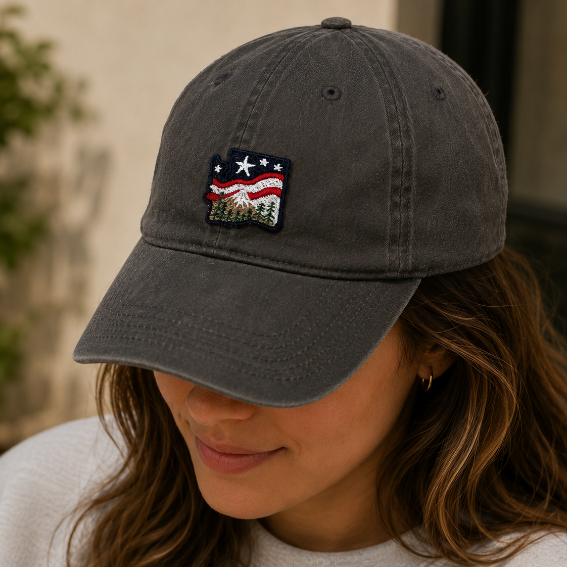 Person wearing a dark gray cap with an embroidered patch outdoors