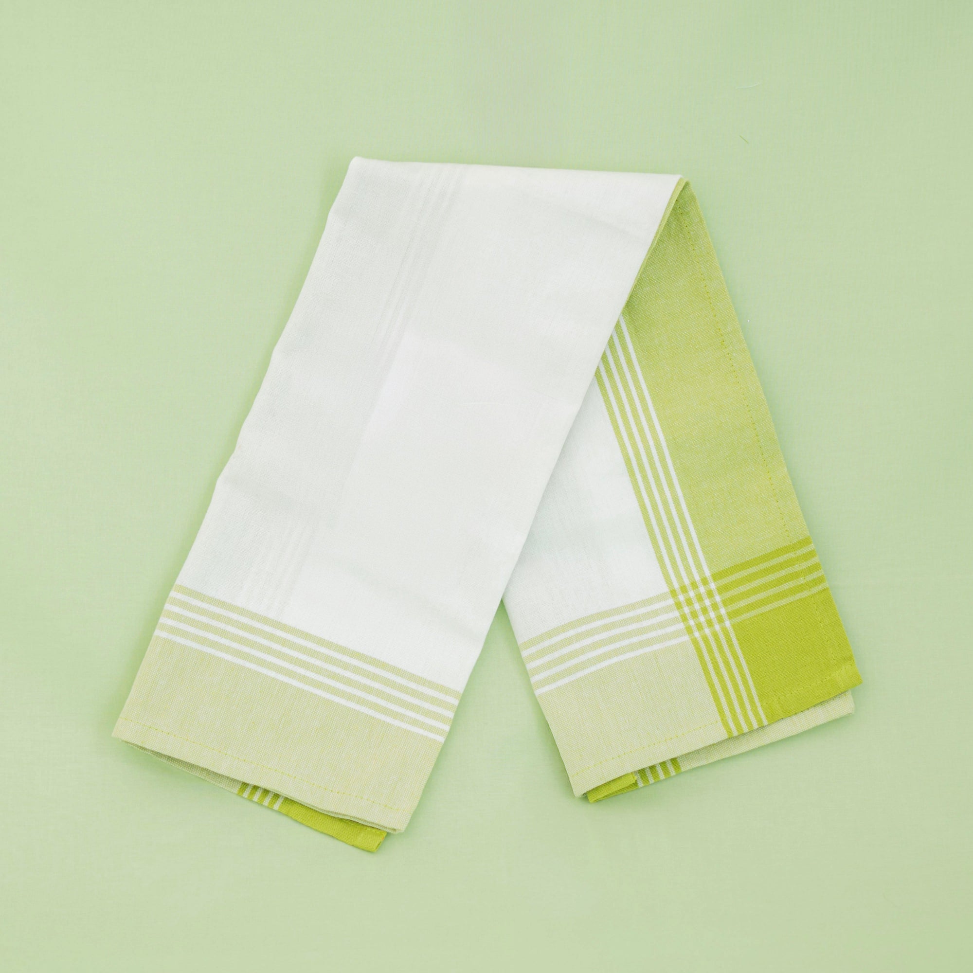 Two green and white striped towels on a light green background