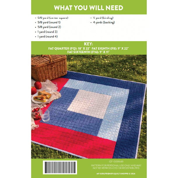 Quilt pattern book cover with quilt displayed on grass, picnic basket, and food.