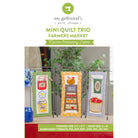 Promotional graphic for 'Mini Quilt Trio Farmers Market' machine embroidery patterns by my girlfriend's quilt shoppe, showing three finished mini quilts hanging on metal stands with a green banner at the bottom detailing embroidery formats and finished size.