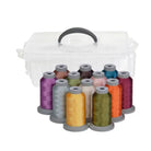 A set of 12 spools of sewing thread in various colors arranged in front of a clear plastic storage case with a black handle, on a white background.