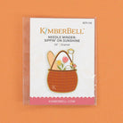 Kimberbell Needle Minder with basket design on a white card against an orange background