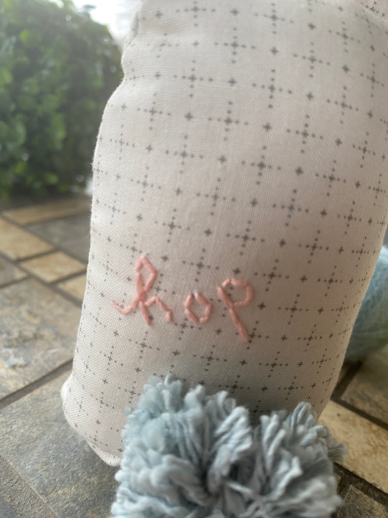 "Hop" hand-embroidered on the back of a bunny pincushion.