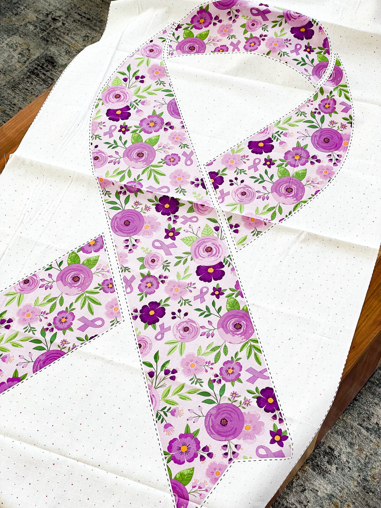 Cancer Awareness Ribbon on a fabric panel.